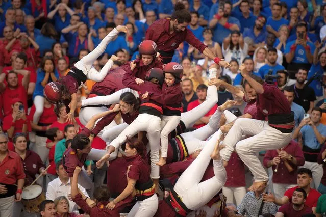 Members of the colla “Jove de Barcelona” fall down as they build a human tower during the 28th Tarragona Competition on October 1, 2022 in Tarragona, Spain. The “Castellers” Catalan tradition was hit hard by the COVID-19 pandemic due to the need to minimize social distance for castle building. This is the first full season since 2019. “Castellers” who build the human towers with precise techniques compete in groups, known as “colles” at local festivals with the aim to build the highest and most complex human tower. The Catalan tradition is believed to have originated from human towers built at the end of the 18th century by dance groups and is part of the Catalan culture. (Photo by David Ramos/Getty Images)