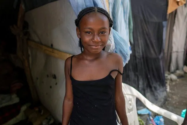 A girl looks at the camera at a shelter for families displaced by gang violence at the Saint Yves Church in Port-au-Prince, Haiti on July 26, 2021. (Photo by Ricardo Arduengo/Reuters)