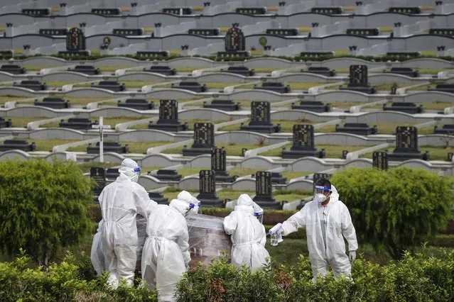 People in protective suits carry a coffin of a person who died with COVID-19 at a graveyard in Setia Alam, outside Kuala Lumpur, Malaysia, 08 June 2021. According to Health director-general Noor Hisham the total COVID-19 cases recorded in Malaysia till 08 June is 627,652 cases. (Photo by Fazry Ismail/EPA/EFE)