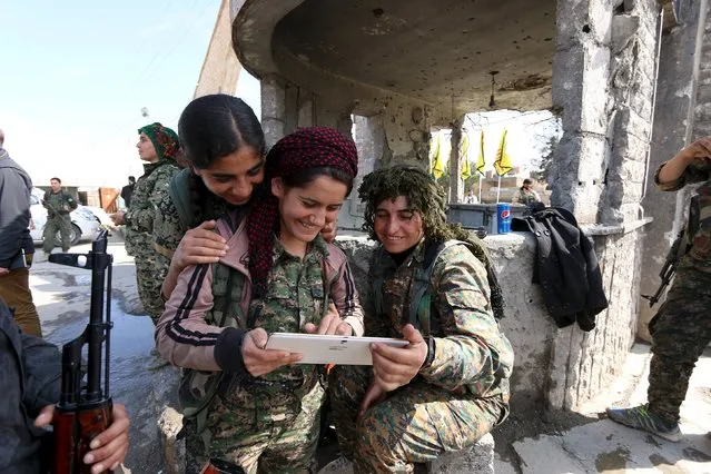 Female fighters from the Democratic Forces of Syria use a tablet in al-Shadadi town, in Hasaka province, Syria February 26, 2016. (Photo by Rodi Said/Reuters)