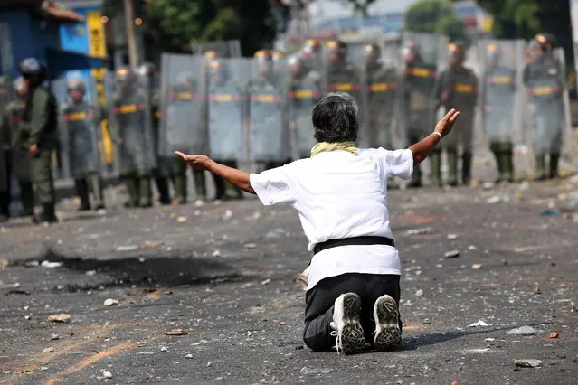 A demonstrator kneels down in front of security forces in Urena, Venezuela, February 23, 2019. (Photo by Andres Martinez Casares/Reuters)