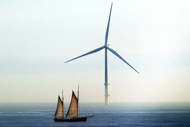 The William II tall ship passes a wind turbine as it sails on a voyage round the coastline of Great Britain on March 19, 2019, calling at 10 ports and changing crews at each stage. (Photo by Owen Humphreys/PA Wire Press Association)