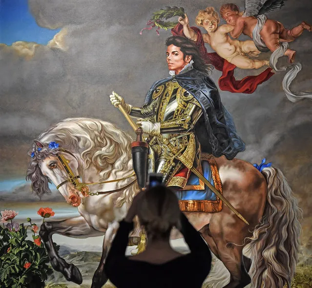 A visitor takes a smartphone picture of the painting “Equestrian portrait of King Philipp II (Michael Jackson)” from US artist Kehinde Wiley at a preview of the exhibition “Michael Jackson: On The Wall” at the Bundeskunsthalle museum in Bonn, Germany, Thursday, March 21, 2019. This work is the final commissioned portrait of Michael Jackson. The exhibition around the controversial iconic pop idol is open until July 14. (Photo by Martin Meissner/AP Photo)