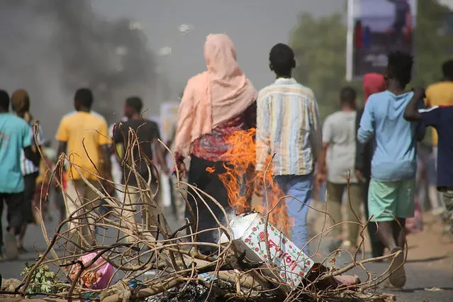 Pro-democracy protesters use fires to block streets to condemn a takeover by military officials in Khartoum, Sudan, Monday October 25, 2021. Sudan’s military seized power Monday, dissolving the transitional government hours after troops arrested the acting prime minister and other officials. The takeover comes more than two years after protesters forced the ouster of longtime autocrat Omar al-Bashir and just weeks before the military was expected to hand the leadership of the council that runs the African country over to civilians. (Photo by Ashraf Idris/AP Photo)