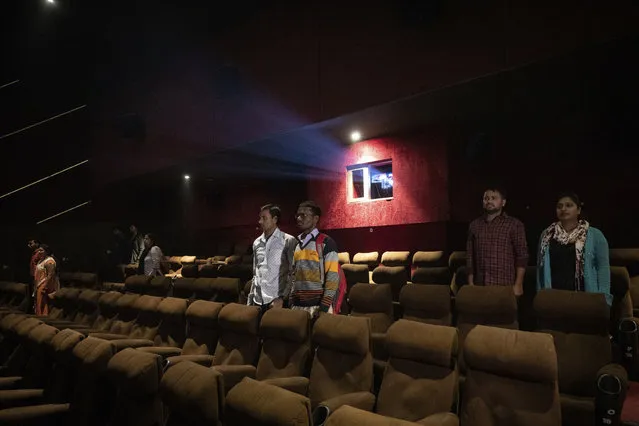 In this Monday, November 26, 2018 photo, moviegoers stand as national anthem is played at a cinema before the screening of a movie in Lucknow, Uttar Pradesh, India. As with similar movements across the world, Hindu nationalism, once fringe, has now taken a central place in India’s politics. (Photo by Bernat Armangue/AP Photo)