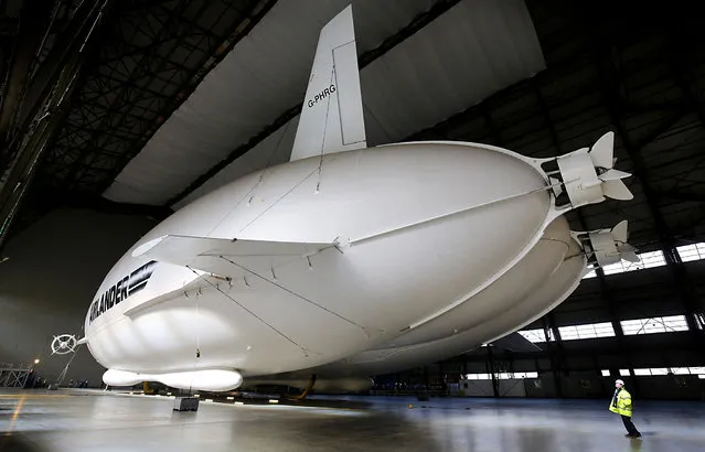 The Airlander 10 airship, the world's largest aircraft, is unveiled for the first time since being fully assembled at Cardington hanger in Bedfordshire on Monday March 21, 2016. The 302ft (92m) long part plane, part airship was first developed for the US government as a long-endurance surveillance aircraft. (Photo by Chris Radburn/PA Wire)