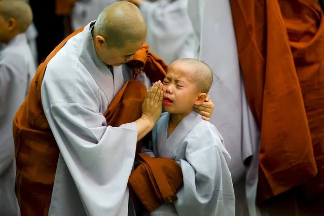 A Buddhist monk comforts a novice monk during an inauguration ceremony at Jogye temple in Seoul, May 11, 2015. (Photo by Thomas Peter/Reuters)