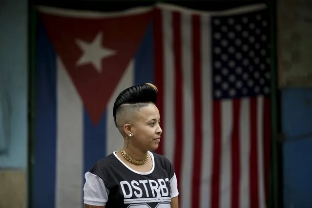 Yaneisy, 28, between jobs, poses for a photograph in front of the Cuban and U.S. flags in Havana, March 25, 2016. Regarding Obama's historic visit to the island, Yaneisy said, “I don't care”. (Photo by Ueslei Marcelino/Reuters)