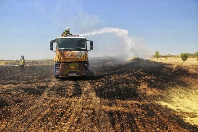 This Tuesday, May 28, 2019 photo, provided by the Syrian Civil Defense White Helmets, which has been authenticated based on its contents and other AP reporting, shows Syrian White Helmet civil defense workers trying to extinguish a fire in a field of crops, in Kfar Ain, the northwestern province of Idlib, Syria. Crop fires in parts of Syria and Iraq have been blamed on defeated Islamic State group militants in the east seeking to avenge the group’s losses, and on Syrian government forces in the west battling to rout other armed groups there. (Photo by Syrian Civil Defense White Helmets via AP Photo)