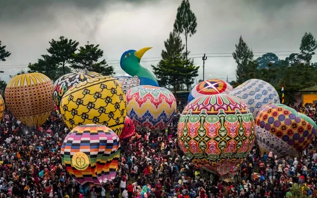 Indonesians prepare to release hundreds of giant baloons at Pagerejo field in Wonosobo, Central Java province on June 15, 2019, during the 2019 Java Traditional Balloon Festival to educate people about flying safety. (Photo by Oka Hamied/AFP Photo)