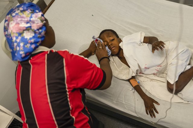 Denize Flerino wipes sweat from the brow of her son who is suffering from high fevers at a Doctors Without Borders emergency room in the Cite Soleil neighborhood of Port-au-Prince, Haiti, April 19, 2024. (Photo by Ramon Espinosa/AP Photo)