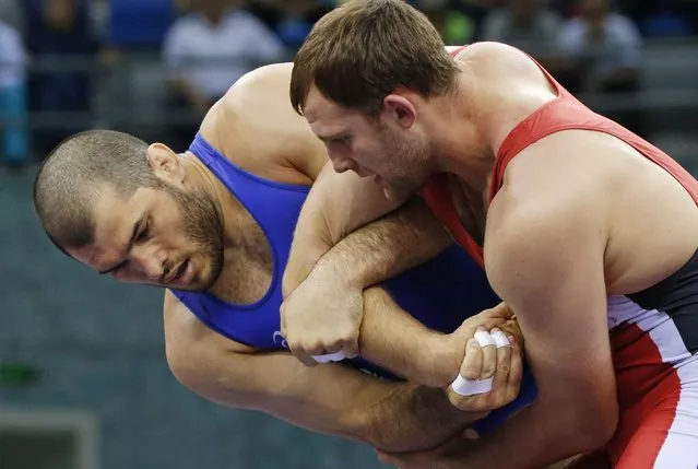 Islam Magomedov of Russia, left, and Dimitriy Timchenko of Ukraine compete in the the Men's wrestling, 98kg Greco-Roman Gold medal event at the 2015 European Games in Baku, Azerbaijan, Saturday, June 13, 2015. (AP Photo/Dmitry Lovetsky)