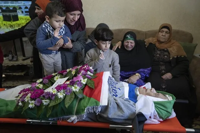Mourners take a last look at the body of Omar Asaad, 80, in the family house, during his funeral in the West Bank village of Jiljiliya, north of Ramallah, Thursday, January 13, 2022. Israel is investigating after Asaad, a Palestinian with U.S. citizenship, died of a heart attack after being detained by Israeli soldiers in the occupied West Bank. (Photo by Nasser Nasser/AP Photo)