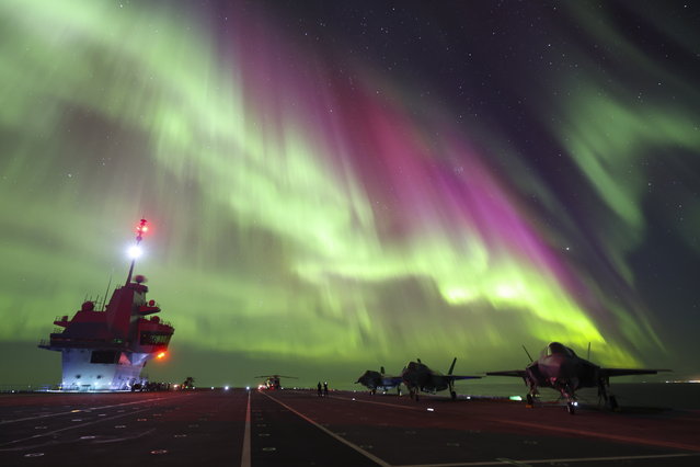 In this photo provided by Britain's Ministry of Defense, on Monday, March 4, 2024, F-35B Lightning jets are parked at a flight deck of HMS Prince of Wales aircraft carrier of the Royal Navy, under the northern lights (Aurora Borealis) near the coast of Norway, Sunday, March 3, 2024. (Photo by UK Ministry of Defence via AP Photo)