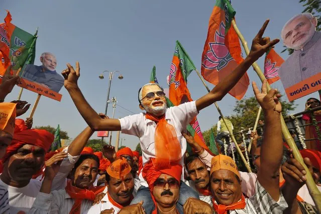 A supporter wearing a mask of Hindu nationalist Narendra Modi, prime ministerial candidate for India's main opposition Bharatiya Janata Party (BJP), cheers as Modi arrives to file nomination papers for the general elections in Vadodara in the western Indian state of Gujarat April 9, 2014. (Photo by Amit Dave/Reuters)