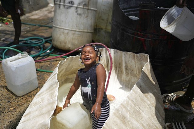 A girl plays in a water container in the Los Guandules neighborhood of Santo Domingo, Dominican Republic, Monday, May 20, 2024. (Photo by Matias Delacroix)/AP Photo