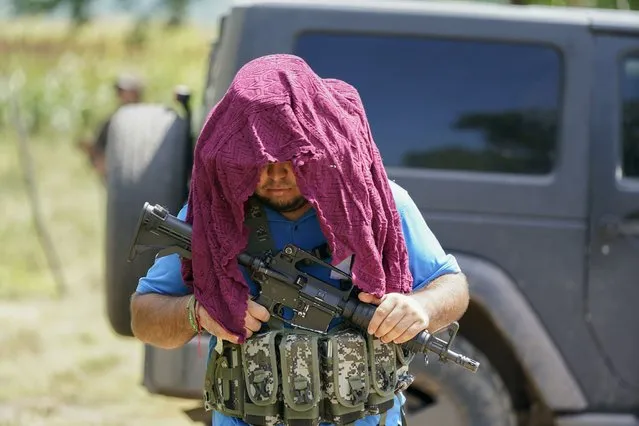 An armed man who claim to be members of a self-defense group patrols the limits of Taixtan in the Michoacan state of Mexico, Thursday, October 28, 2021. The army has largely stopped fighting drug cartels here, instead ordering soldiers to guard the dividing lines between gang territories so they won’t invade each other’s turf – and turn a blind eye to the cartels’ illegal activities. (Photo by Eduardo Verdugo/AP Photo)