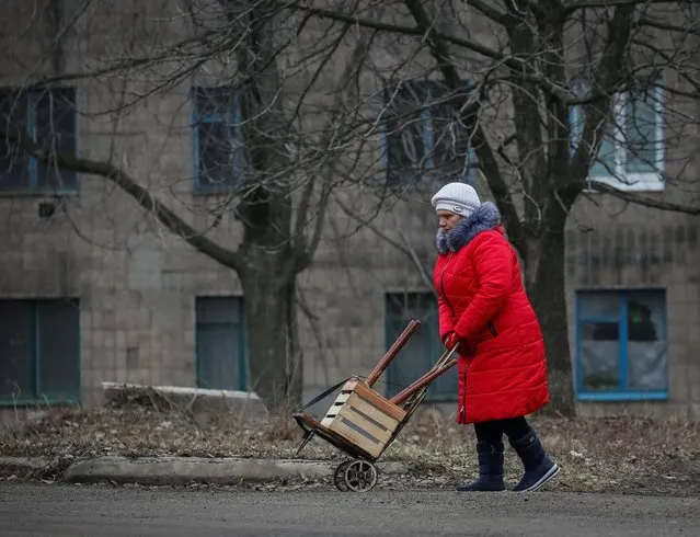 A local resident walks along a street near the front line near the city of Novoluhanske in the Donetsk region, Ukraine on February 22, 2022. (Photo by Gleb Garanich/Reuters)