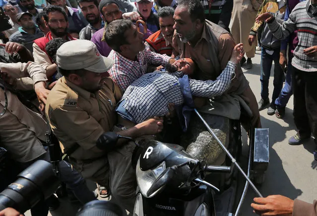Indian policemen detain a physically challenged member of All Jammu and Kashmir Handicapped Association (AJKHA) during a protest demanding a raise in monthly allowance and accommodation promised by the government, a protestor said, in Srinagar May 10, 2016. (Photo by Danish Ismail/Reuters)