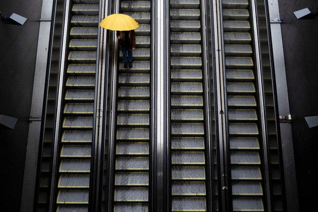 A person with an umbrella goes down an escalator at a subway station during heavy rain in Santiago, Chile, Thursday, June 13, 2024. (Photo by Matias Basualdo/AP Photo)