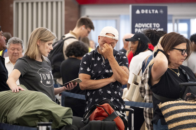 Tiffany McAllister and Andres Bernal try to rebook their flight to Iowa while at Hartsfield Jackson International Airport in Atlanta, Friday, July 19, 2024, as a major internet outage disrupts flights, banks, media outlets and companies across the world. (Photo by Ben Gray/AP Photo)