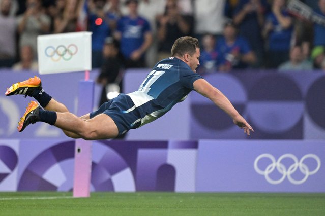 France's Antoine Dupont dives with the ball to score a try during the men's quarter final rugby sevens match between Argentina and France during the Paris 2024 Olympic Games at the Stade de France in Saint-Denis on July 25, 2024. (Photo by Carl de Souza/AFP Photo)