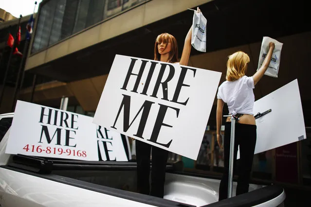 Motorized mannequins hold signs that read “Hire Me” in Toronto May 23, 2014. Canada's economy unexpectedly shed 28,900 jobs in April, mainly due to steep declines in full-time employment and in the private sector, Statistics Canada data indicated earlier this month. (Photo by Mark Blinch/Reuters)