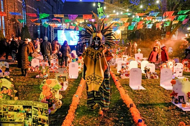 Veronica attends a procession by her Mexican-American community of Pilsen celebrating the Day of the Dead in Chicago, Illinois, November 2, 2019. Veronica came to the U.S. by crossing a river at 9 years old. Ten years ago, she couldn't be there for her father's burial in Mexico, so she decided to create a cemetery in her community of Pilsen where families can decorate “graves” as offerings. “When the flags blow in the wind that means they're coming”, says Veronica. (Photo by Maria Alejandra Cardona/Reuters)