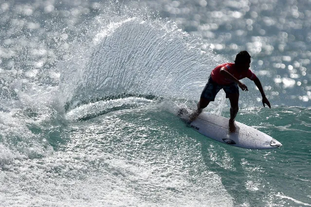 Rio Waida of Indonesia rides a wave during the men's final pro junior surfing competition at Kuta beach on Indonesia's resort island of Bali on March 9, 2022. (Photo by Sonny Tumbelaka/AFP Photo)