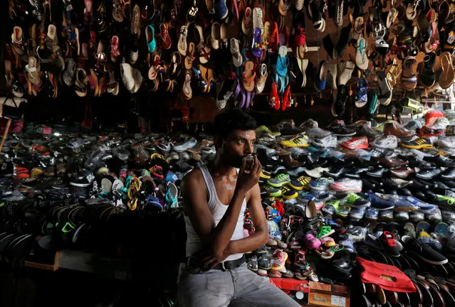 A shopkeeper drinks tea as he waits for customers at his roadside footwear stall in Kolkata, India May 30, 2016. (Photo by Rupak De Chowdhuri/Reuters)