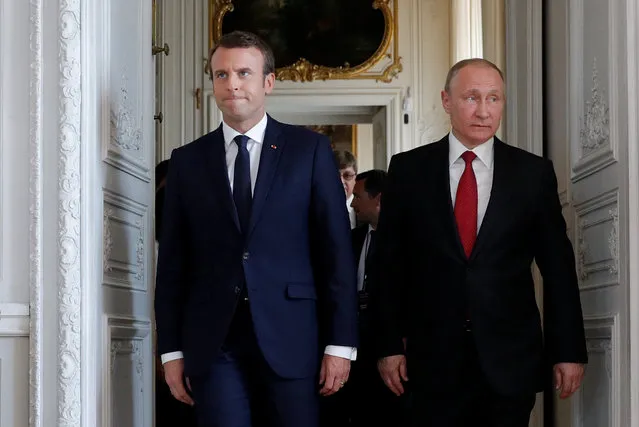 French President Emmanuel Macron (L) walks with Russian President Vladimir Putin at the Chateau de Versailles as they meet for talks before the opening of an exhibition marking 300 years of diplomatic ties between the two countries in Versailles, France, May 29, 2017. (Photo by Philippe Wojazer/Reuters)