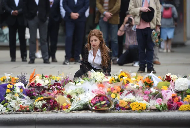 A woman reacts next to flowers left on the south side of London Bridge near Borough Market after an attack left 7 people dead and ozens of injured in London, Britain, June 5, 2017. (Photo by Clodagh Kilcoyne/Reuters)