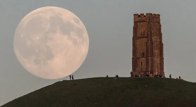 The moon rises over people gathered on Glastonbury Tor ahead of tomorrow's Blue Moon on July 30, 2015 in Somerset, England. The full moon appearing on July 31 will be what's called a Blue Moon, which refers to the second of two full moons appearing in the same calendar month. The last time this happened was in 2012 and there isn't due another until 2018. (Photo by Matt Cardy/Getty Images)