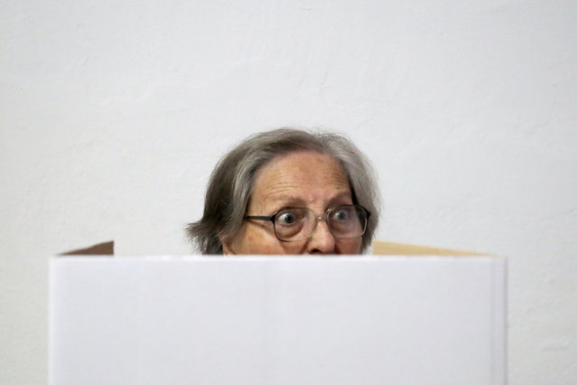 A woman casts her ballot at a polling station during the presidential election in Zagreb, Croatia on December 22, 2019. (Photo by Marko Djurica/Reuters)