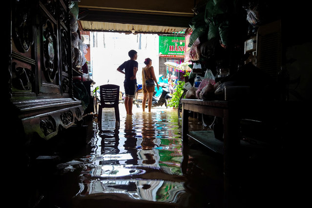 Shop owners stand inside their flooded shop following the impact of Typhoon Yagi, in Hanoi, Vietnam on September 11, 2024. (Photo by Khanh Vu/Reuters)