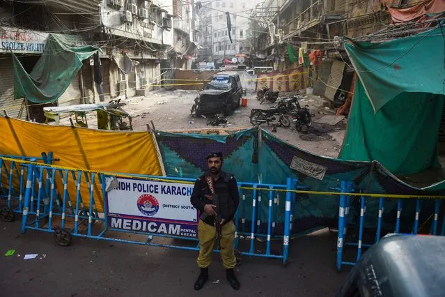 A policeman stands guard at the site of a bomb blast, that killed one and injured nine people, a day after in Karachi on May 17, 2022. (Photo by Rizwan Tabassum/AFP Photo)