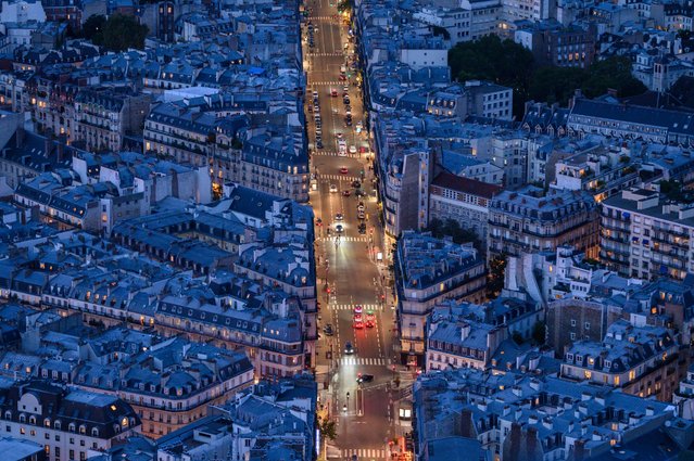 This aerial photograph shows pedetrians and drivers commuting on a boulevard in Paris on September 15, 2024. (Photo by Ed Jones/AFP Photo)