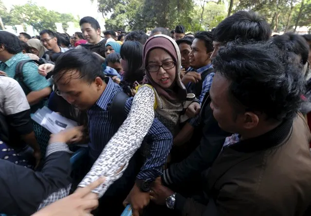 An Indonesian youth pulls along her friend's arm as they jostle within a queue at the Indonesia Spectacular Job Fair 2015 at Gelora Bung Karno stadium in Jakarta August 12, 2015. (Photo by Reuters/Beawiharta)