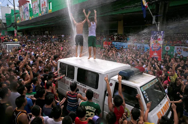 A fireman hoses people with water as residents join in a water-splashing frenzy to honor their patron Saint John the Baptist's Feast Day in San Juan, Metro Manila, Philippines June 24, 2016. (Photo by Romeo Ranoco/Reuters)
