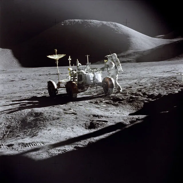 Astronaut James B. Irwin, Lunar Module pilot, works at the Lunar Roving Vehicle during the first Apollo 15 lunar surface extravehicular activity (EVA-1) at the Hadley-Apennine landing site. The shadow of the Lunar Module “Falcon” is in the foreground. This view is looking northeast, with Mount Hadley in the background. This photograph was taken by Astronaut David R. Scott, Commander. (Photo by NASA)