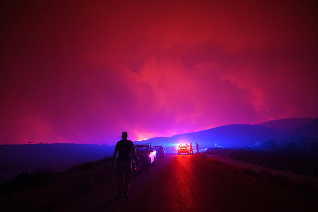 Firefighters and volunteers operate during a wildfire, in Palagia village, Alexandroupolis, Thrace, northern Greece on August 22, 2023. The Alexandroupolis General Hospital was evacuated as a large fire was approaching the northern Greek city. Patients were evacuated with ambulances provided by the Health Ministry and the help of a large police force stationed in the region for the purpose.Two separate messages of the 112 emergency service had been issued to residents of Alexandroupolis, a major port and energy hub, alerting them to heavy smoke from fires in the region and ordering them to stay indoors with shut doors and windows. After 02.00 in the morning, the villages of Dikela, Makri, Nea Chili, Elaionas, Ag. Giorgis, Plaka, Enato and Pefki were also evacuated. (Photo by Dimitris Alexoudis/EPA/EFE)