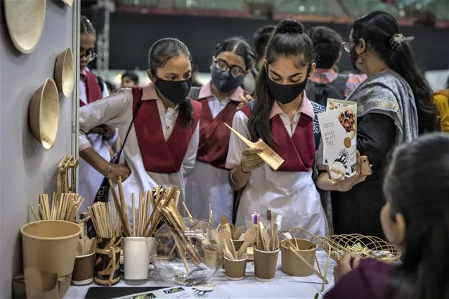 Schoolgirls look at items which are an alternate to plastic at an event to create awareness about eco-friendly products in New Delhi, India, Friday, July 1, 2022. (Photo by Altaf Qadri/AP Photo)
