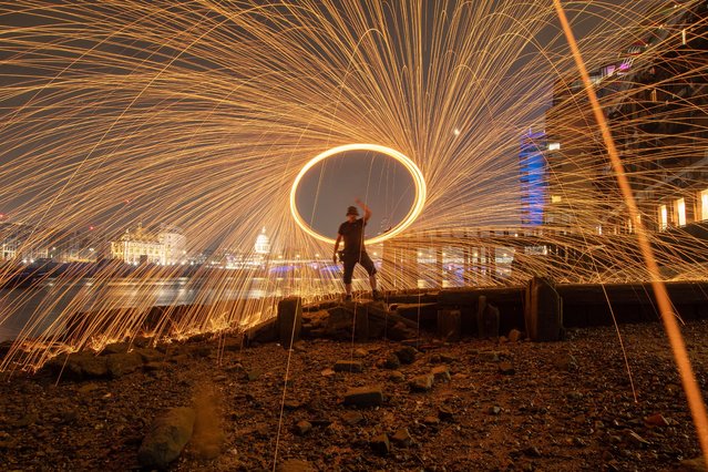 A member of the London Fire Spinners, a performance collective, makes sparks fly from burning steel wool at Gabriel’s Wharf along the River Thames on September 23, 2024. The picture was taken with an eight-second exposure. (Photo by Kevin Jay/Picture Exclusive)