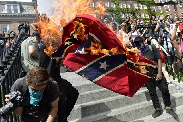 Black Lives Matter members burn a Confederate flag at the Boston Free Speech Rally in Boston, USA on August 19. 2017. (Photo by Paul Marotta/Rex Features/Shutterstock)
