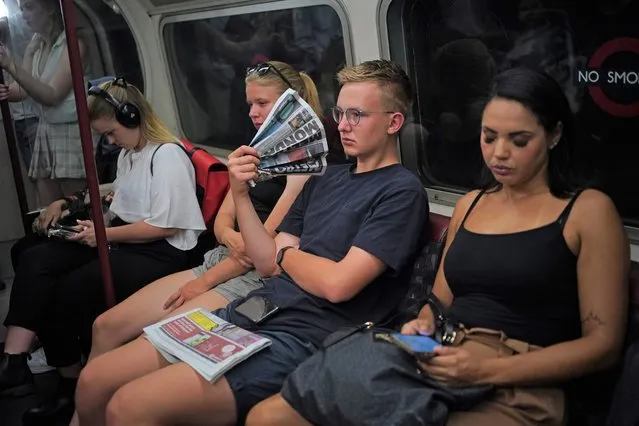 A man uses a newspaper as a fan whilst travelling on the Bakerloo line in central London during the heatwave on Monday, July 18, 2022. Transport for London has advised people to “only travel if essential” amid the extreme heat. (Photo by Yui Mok/PA Images via Getty Images)