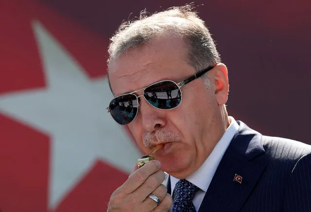 Turkish President Tayyip Erdogan blows a watchmen whistle during a ceremony in Istanbul, Turkey, August 25, 2017. (Photo by Murad Sezer/Reuters)