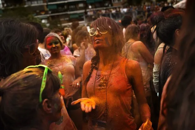 Revelers of the Holi Festival of Colors throw colored powders in the air in Madrid, Spain, Saturday, August 9, 2014. The festival is fashioned after the Hindu spring festival Holi, which is mainly celebrated in the north and east areas of India. (Photo by Daniel Ochoa de Olza/AP Photo)