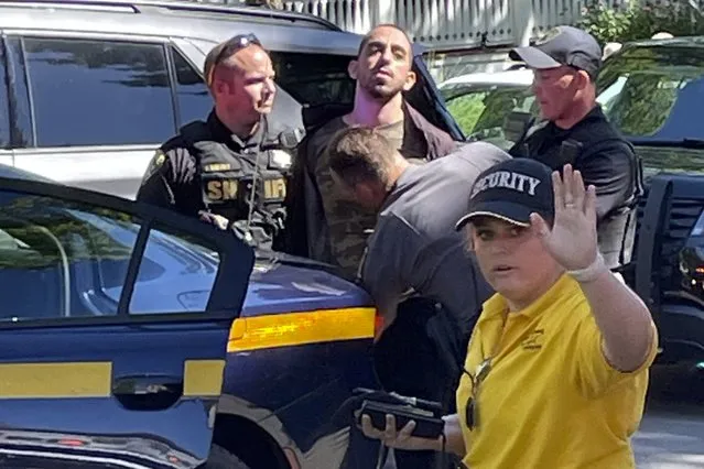 Law enforcement officers detain Hadi Matar, 24, of Fairview, N.J., outside the Chautauqua Institution, Friday, August 12, 2022, in Chautauqua, N.Y Salman Rushdie, the author whose writing led to death threats from Iran in the 1980s, was attacked and apparently stabbed in the neck Friday by Matar who rushed the stage as he was about to give a lecture at the institute in western New York. (Photo by Charles Fox via AP Photo)