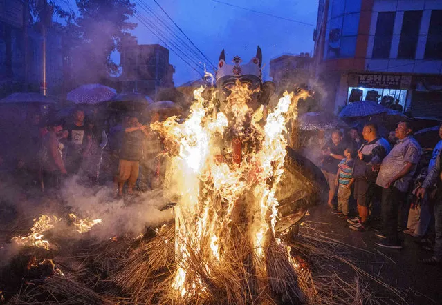 Nepalese people burn an effigy of demon Ghantakarna to represent demolition of evil during the Ghantakarna festival in Bhaktapur, Nepal, Tuesday, July 26, 2022. (Photo by Niranjan Shrestha/AP Photo)
