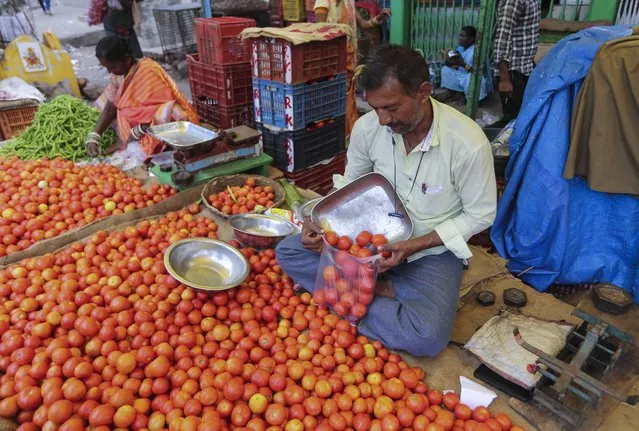 A vendor puts tomatoes in a single use plastic cover at a wholesale vegetable market in Hyderabad, India, Thursday, June 30, 2022. India banned some single-use or disposable plastic products Friday as a part of a longer federal plan to phase out the ubiquitous material in the nation of nearly 1.4 billion people. (Photo by Mahesh Kumar A./AP Photo)
